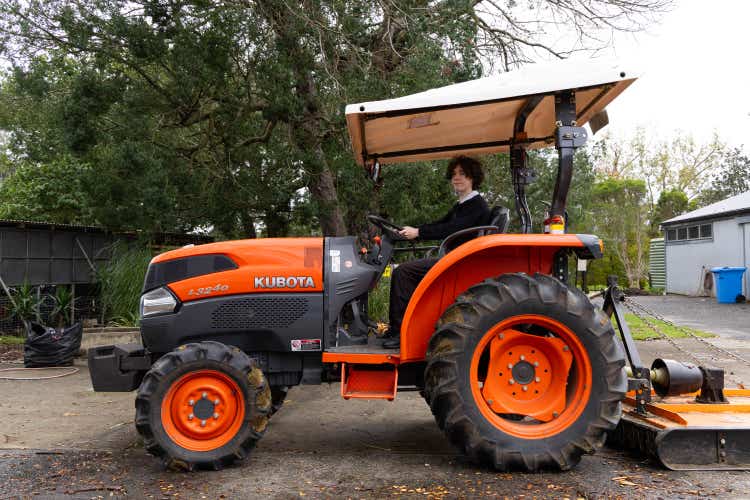 Student driving a tractor on our farm